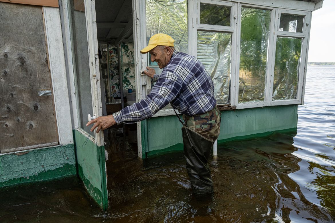 Mykola Gurzhiy, 74, a local fisherman opens a door of his flooded house in the island of Kakhovka reservoir on Dnipro river near Lysohirka, Ukraine