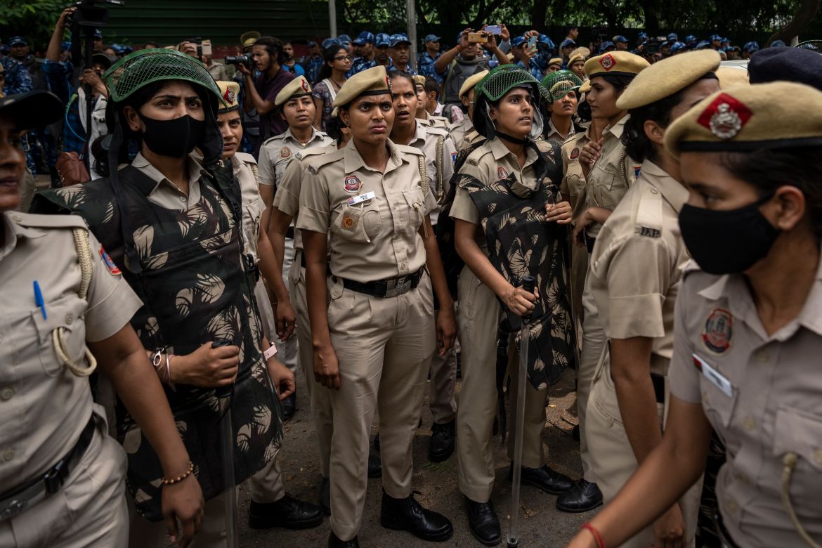 Police women watch as India's top female wrestlers are detained by the police