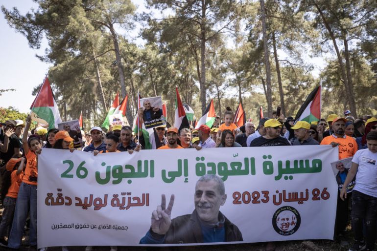 Palestinians carry the flag and photographs of Palestinian prisoner in Israeli jail Walid Daqqa, who is diagnosed with spinal cord cancer