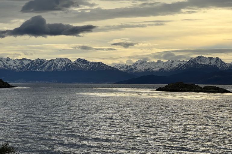 wide view of Navarino Island with snow-capped mountains in background and sea in foreground
