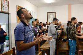 Israel Domingos claps during a spiritual gathering in Apac prison