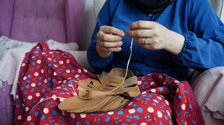 A woman sews shoes