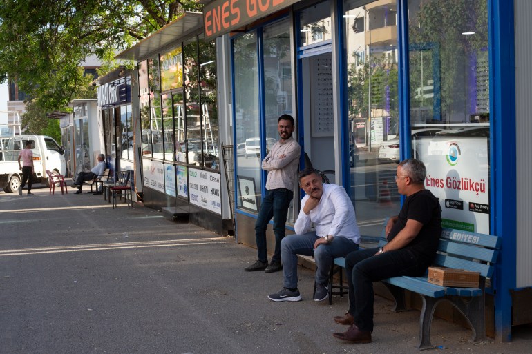 Mesut Islamoğlu, centre, outside his recently-reopened store