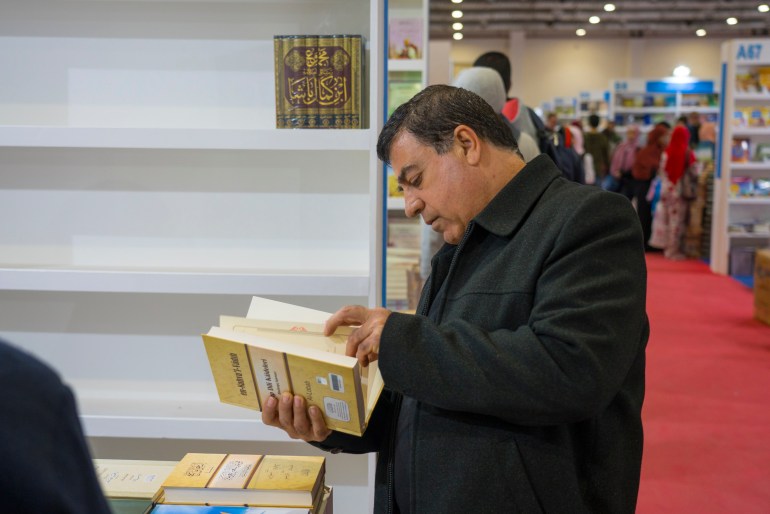 Michel reading a book at a book fair
