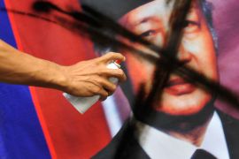 A banner bearing the portrait of former Indonesian dictator General Muhammad Soeharto is vandalized by a demonstrator during a rally in Jakarta on October 25, 2010 [Aldo Utama/AFP]