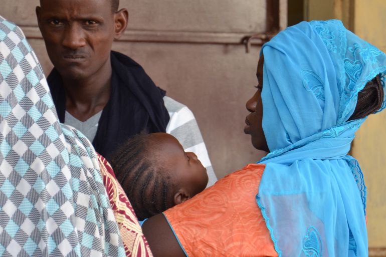 A woman carries her sick child to the health center of Lazaret, near Niamey, on April 23, 2015, where are treated patients suffering from meningitis.