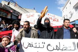Demonstrators carry signs during an anti-government protest in Tunis, Tunisia January 26, 2021.