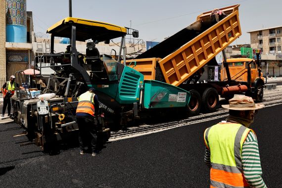 Iraqi workers lay asphalt in Baghdad