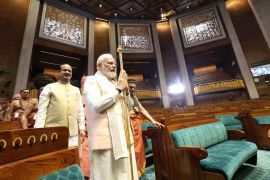Prime Minister Narendra Modi carries a sengol as Lok Sabha Speaker Om Birla looks on during the inauguration of the new Parliament building in New Delhi, May 28, 2023