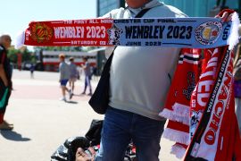 General view as a Manchester City and Manchester United scarf is displayed outside Old Trafford ahead of the FA Cup Final [Molly Darlington/Reuters]
