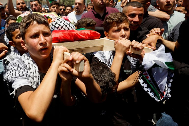 Mourners carry the body of three-year-old Palestinian boy Mohammad al-Tamimi who died of his wounds after being shot by Israeli forces