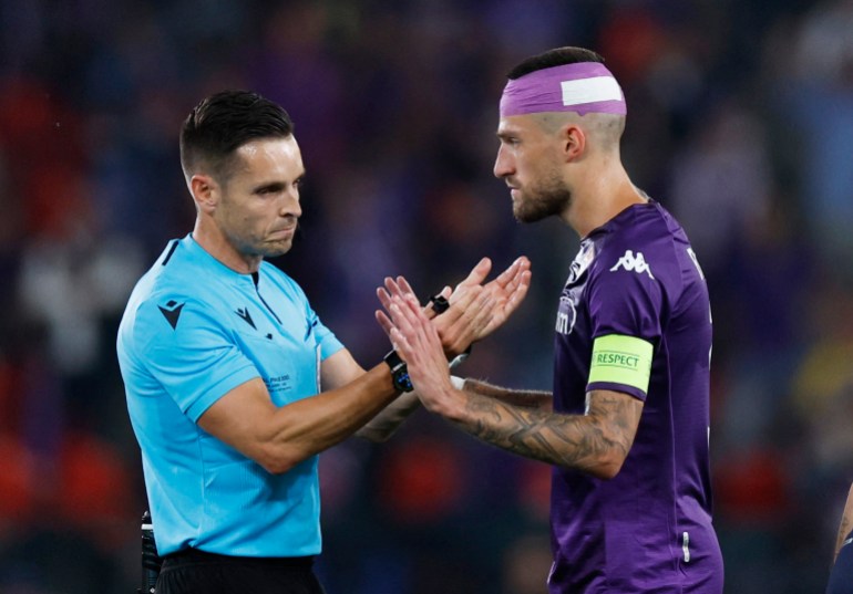 Soccer Football - Europa Conference League - Final - Fiorentina v West Ham United - Eden Arena, Prague, Czech Republic - June 7, 2023 Fiorentina's Cristiano Biraghi speaks to referee Carlos Del Cerro after cups were thrown at him by West Ham United fans REUTERS/David W Cerny