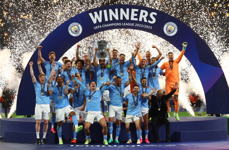 City's Ilkay Gundogan lifts the trophy as he celebrates with teammates after winning the Champions League. [REUTERS/Molly Darlington]