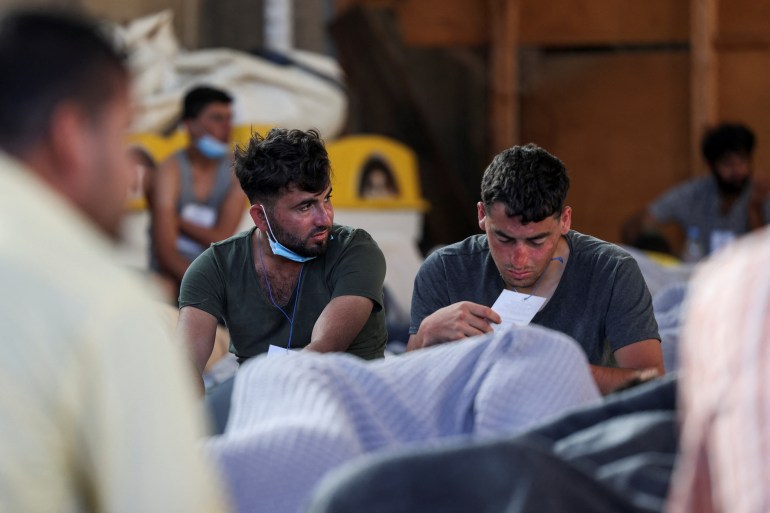 Migrants rest in a shelter in Kalamata