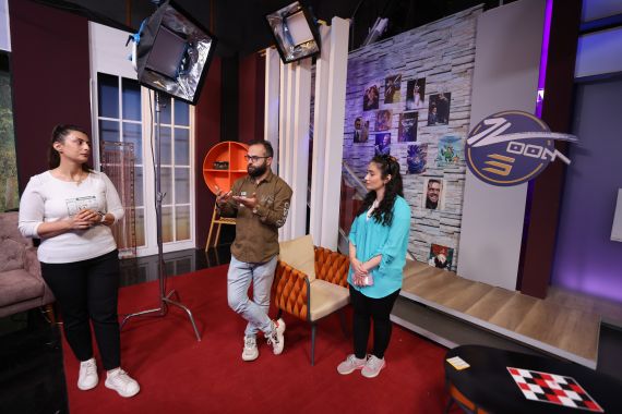 Mariam Ashur (R) and Mariam Albert (L), presenters of a television program airing on 'al-Syriania' television channel, stand with channel director Jack Anwia in a studio in Baghdad.