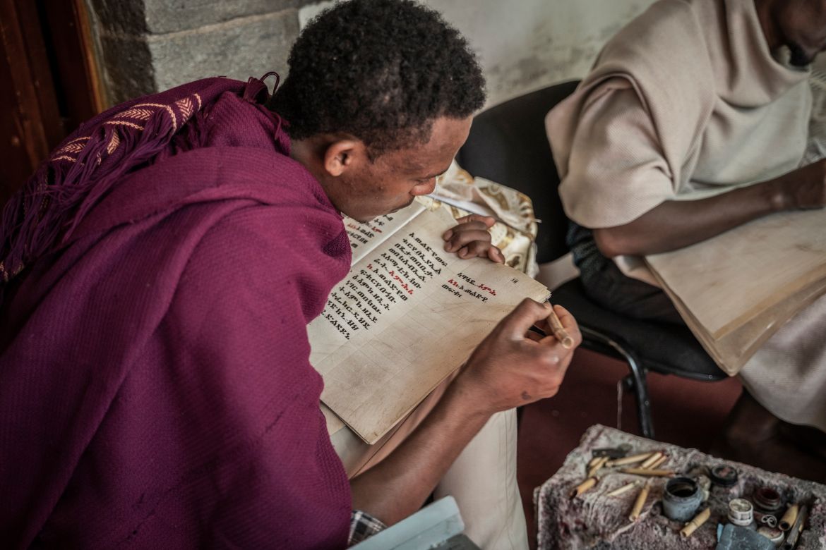 Abel Tebke, 23, a member of Hamere Berhan initiative writes scriptures in Ge'ez language on parchment made of goat skin