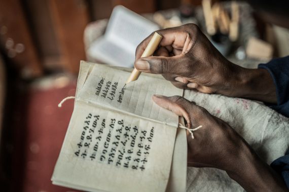 A member of Hamere Berhan initiative writes scriptures in Ge'ez language on parchment made of goat skin