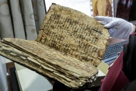 The Chaldean Catholic Archbishop of Mosul, Michaeel Najeeb, holds an ancient Christian codex in Syriac at the Eastern Manuscript Digitisation Centre (CNMO) in Erbil, the capital of Iraq&#39;s autonomous northern Kurdish region. [Safin Hamid/AFP]