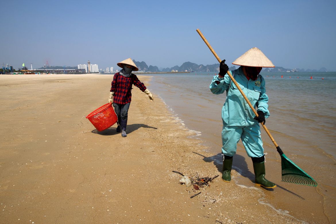 a worker picks up trash from Ha Long Bay in northeast Vietnam.