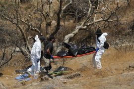 Forensic experts work with several bags of human remains extracted from the bottom of a ravine by a helicopter, which were abandoned at the Mirador Escondido community in Zapopan, Jalisco state, Mexico on May 31, 2023. - The Jalisco Prosecutor's Office is investigating to find out if the remains belong to the 7 call center workers who disappeared on their way to work in recent days. (Photo by ULISES RUIZ / AFP)