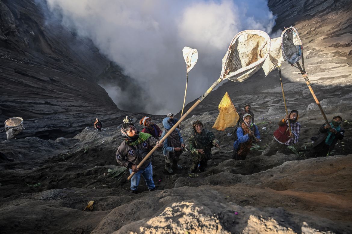 Villagers use nets to catch offerings thrown by members of the Tengger sub-ethnic group in the crater