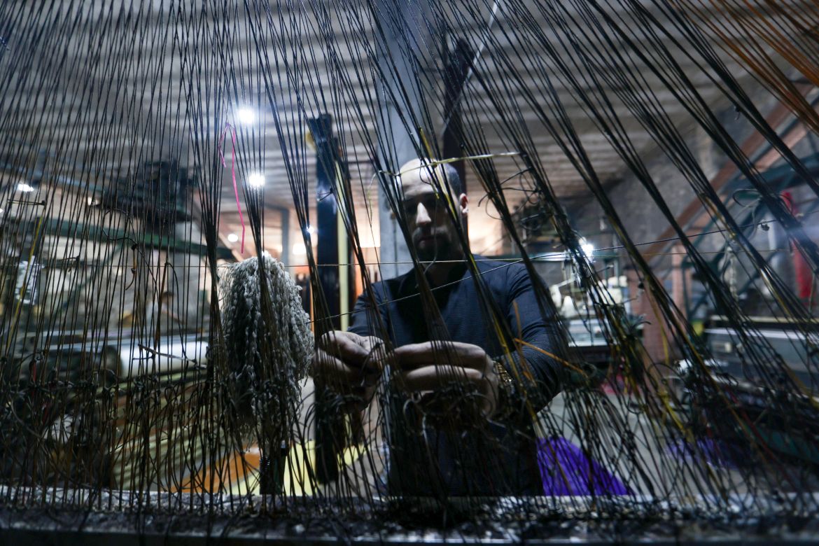In this picture taken on June 1, 2023, a man works at a factory making mats and rugs