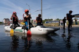 Ukrainian security forces wait in a boat prior to evacuate local residents from a flooded area in Kherson [Aleksey Filippov/AFP]