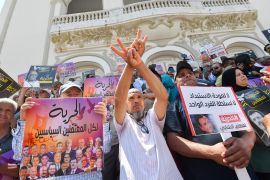 People lift placards demanding the release of political prisoners during a demonstration in Tunis