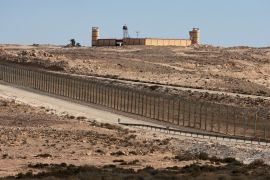 This photo taken on August 17, 2021 shows the Egyptian army behind a border fence between Israel and Egypt in the Naqab (Negev) desert some 30 kilometres south of Nitzana [File: AFP]