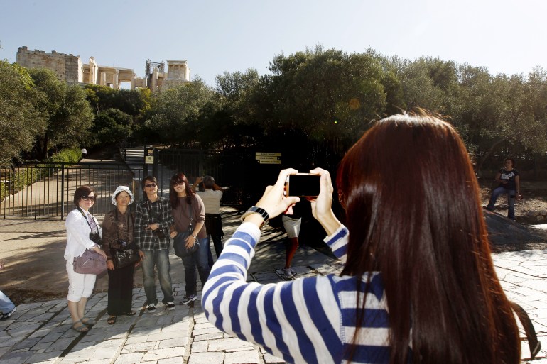 Chinese tourists taking photos with Acropolis in the background