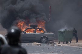 A demonstrator takes cover during clashes