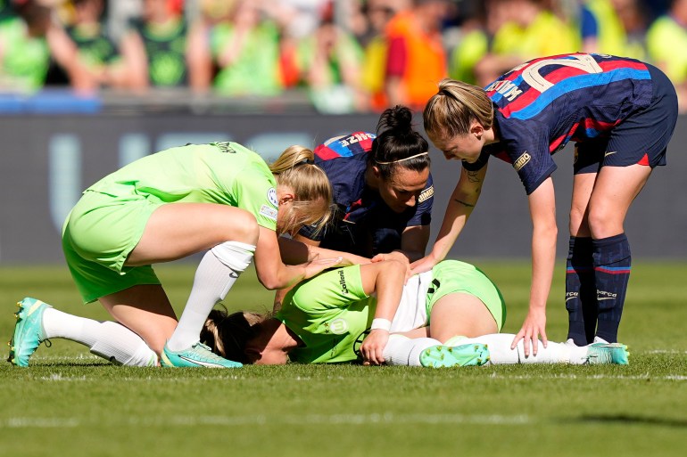 Wolfsburg's Alexandra Popp lies on the ground after getting injured during the Women's Champions League final soccer match between FC Barcelona and VfL Wolfsburg at the PSV Stadion in Eindhoven. [AP Photo/Martin Meissner]