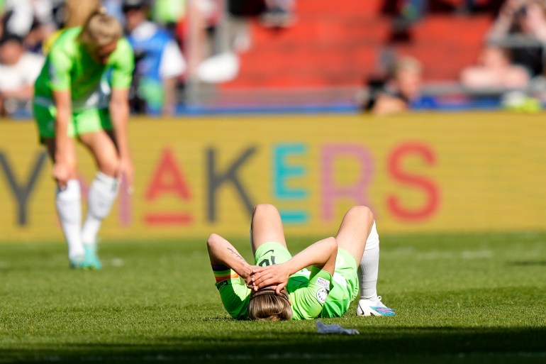 Wolfsburg's captain Svenja Huth lies on the ground at the end of the Women's Champions League final soccer match between FC Barcelona and VfL Wolfsburg at the PSV Stadion in Eindhoven, Netherlands, Saturday, June 3, 2023. Barcelona won 3-2. (AP Photo/Martin Meissner)