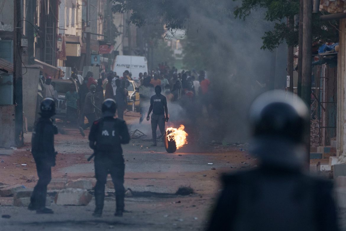 A demonstrator stand in the middle of a street during clashes with riot policemen