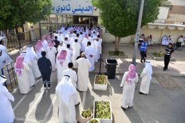 People stand in line to cast their votes in National Assembly elections at a religious school in Sabahiya district, Kuwait [Jaber Abdulkhaleg/AP]