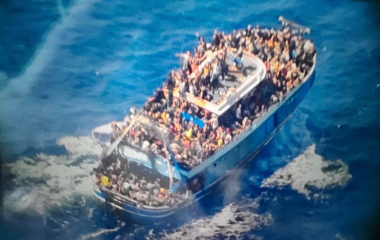 scores of people covering practically every free stretch of deck on a battered fishing boat that later capsized and sank off southern Greece