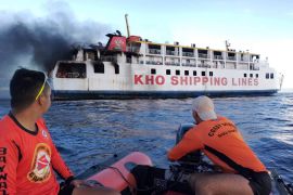 Philippine Coast Guard personnel assist in putting out the fire on M/V Esperanza Star at the waters off Panglao, Bohol province, central Philippines