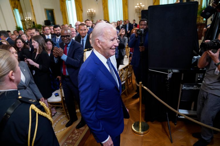 US President Joe Biden leaves a crowded room after speaking at an event on high-speed internet infrastructure in the East Room of the White House.