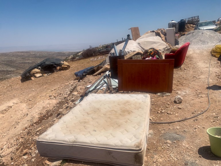 A matress, soiled by the move, lies on the ground near Ibrahim's family's items from their old home