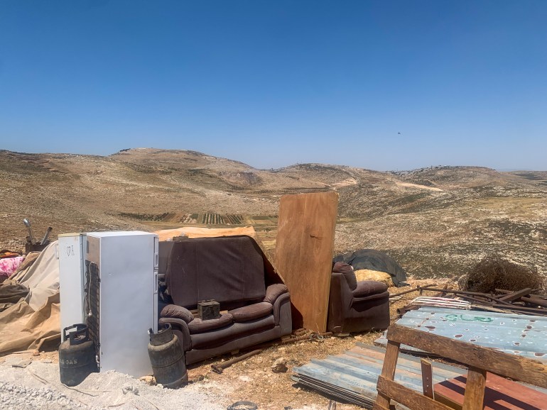 Sofas, refrigerators, cooking gas canisters and corrugated metal lie on the ground