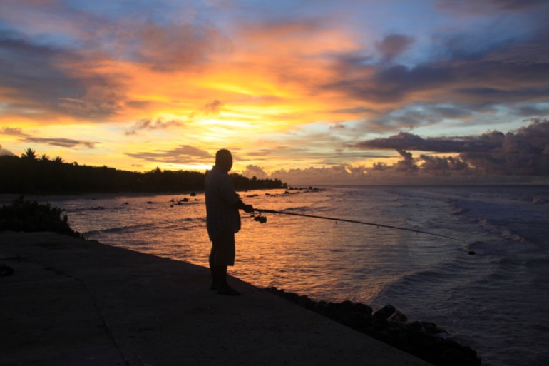 A fisherman is pictured at sunset at the northern end of the airport runway on the small nation island of Nauru