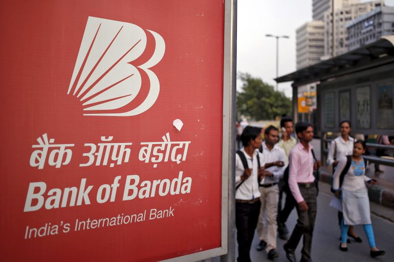 Commuters walk past an advertisement of Bank of Baroda, India's second-biggest state-owned bank, at a busy street in New Delhi, India