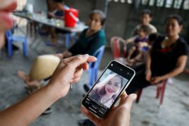 A relative looks at an image of Anna Bui Thi Nhung, a victim who was found dead in the back of British truck in 2019, at her home in Nghe An province, Vietnam October 26, 2019. Picture taken October 26, 2019 [Kham/Reuters]