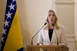 Zeljka Cvijanovic, newly elected Serb member of Bosnia's tripartite inter-ethnic presidency, attends the presidential inauguration ceremony in Sarajevo, Bosnia and Herzegovina November 16, 2022. She stands in a white suit and black shirt behind a podium set up with two microphones.