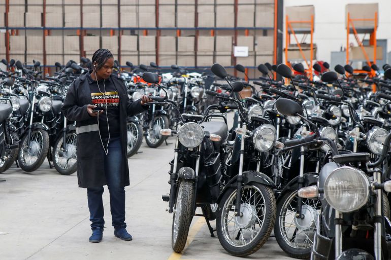 A worker stands next to assembled electric motorcycles at ARC Ride's warehouse in Industrial Area, Nairobi, Kenya November 2, 2022. REUTERS/Monicah Mwangi