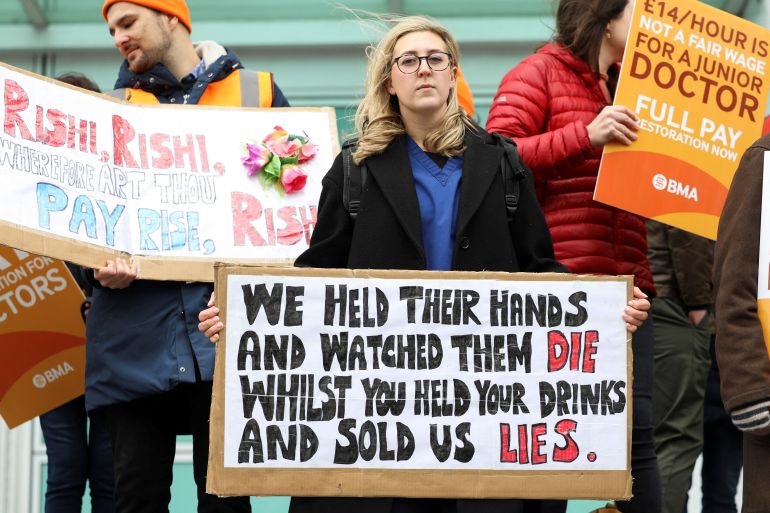 People hold placards as they attend a protest by junior doctors, amid a dispute with the government over pay, at University College London Hospitals in London, Britain, March 13, 2023. REUTERS/May James