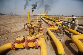 A worker checks an oil pipeline at Nahr Bin Umar oil field, north of Basra on March 22, 2022 [File: Reuters/Essam Al-Sudani]