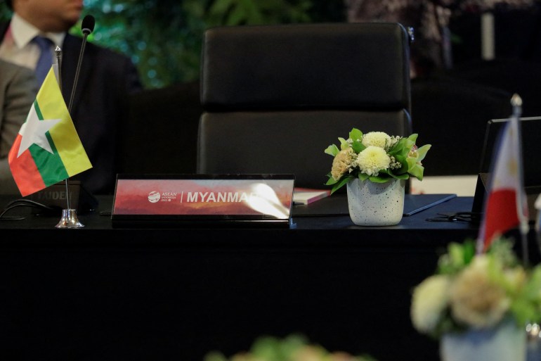 Myanmar's empty chair at an ASEAN meeting. There is a small vase of white flowers on the table. 
