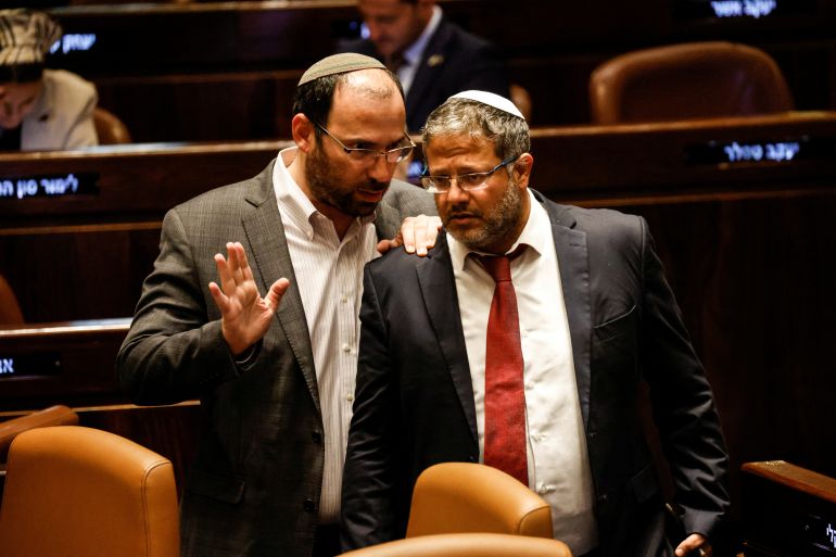 Israeli National Security Minister Itamar Ben-Gvir and Head of the Knesset Constitution, Law and Justice Committee Simcha Rothman speak as lawmakers gather at the Knesset plenum to vote on a bill that would limit some Supreme Court power