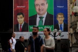 Spain's Socialist Party leader and Prime Minister Pedro Sanchez and opposition People's Party leader Alberto Nunez Feijoo are pictured alongside Basque Nationalist Party (PNV) candidate Aitor Esteban on a poster reading, 'Sanchez?, Feijoo? Here, PNV.' in Bilbao, Spain, July 24, 2023. REUTERS/Vincent West